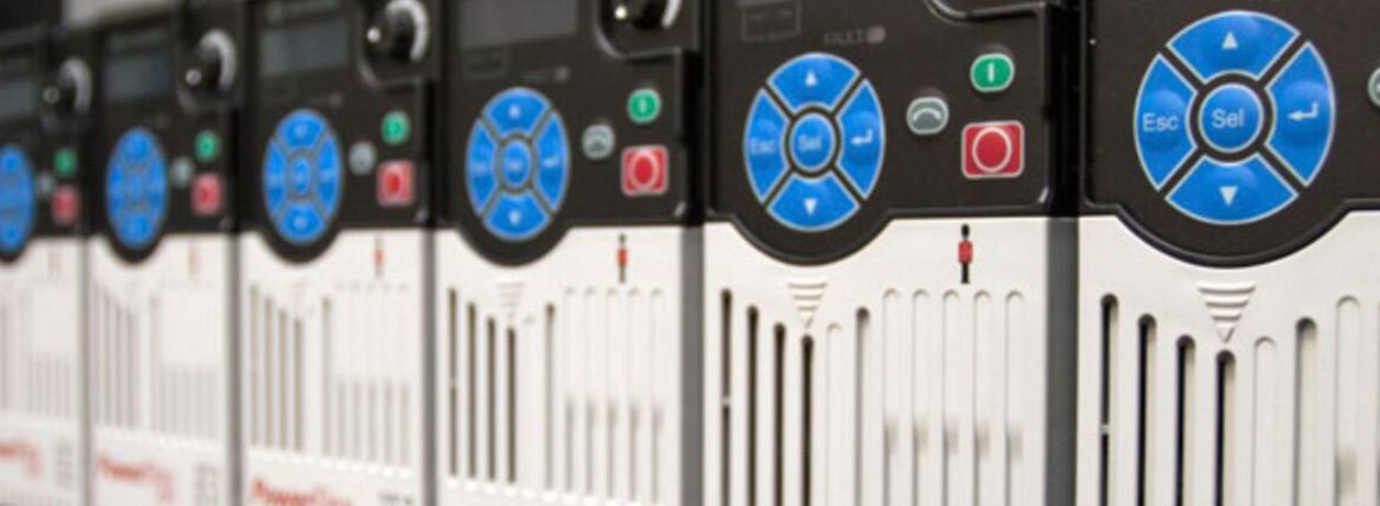 Row of variable frequency drives with blue keypads, status lights, and ventilation slots