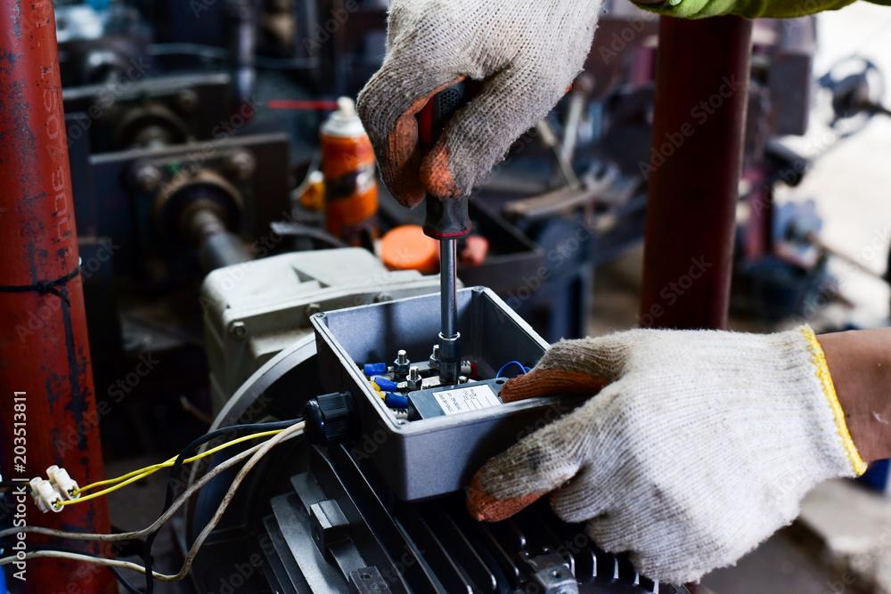 Electricians installing and wiring an industrial panel on site